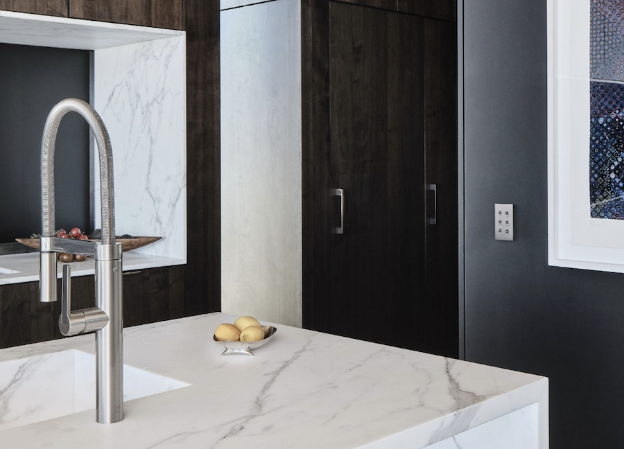 Kitchen counter with faucet and sink on the left and a Meljac control keypad on the left-hand wall