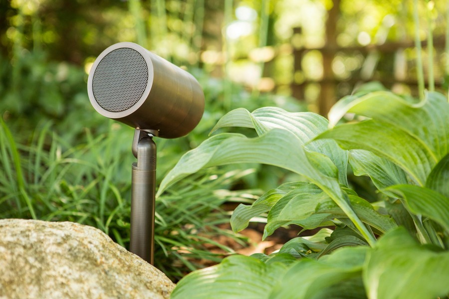 A Coastal Source Modulus Bullet speaker installed by a small rock.
