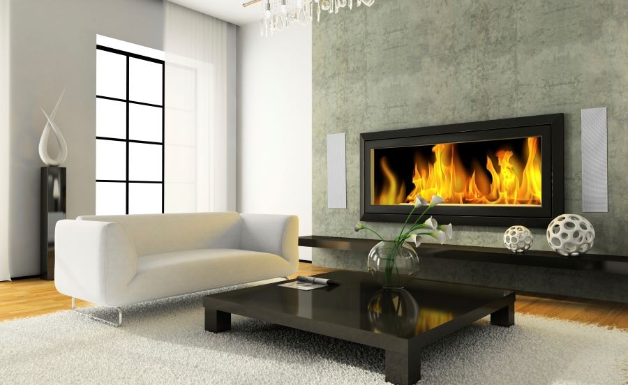 A living room with a fireplace and Meridian in-wall speakers on either side.